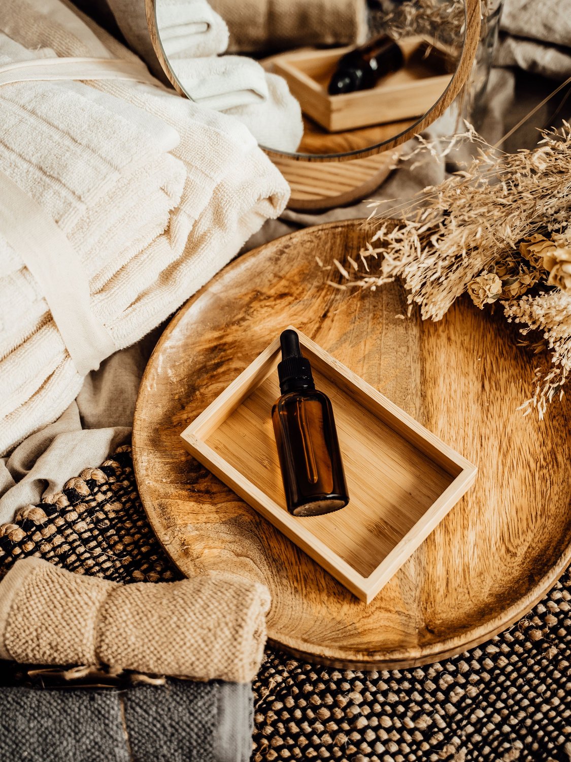 Warm massage oils, folded towels, and botanicals at Transformations Massage & Wellness