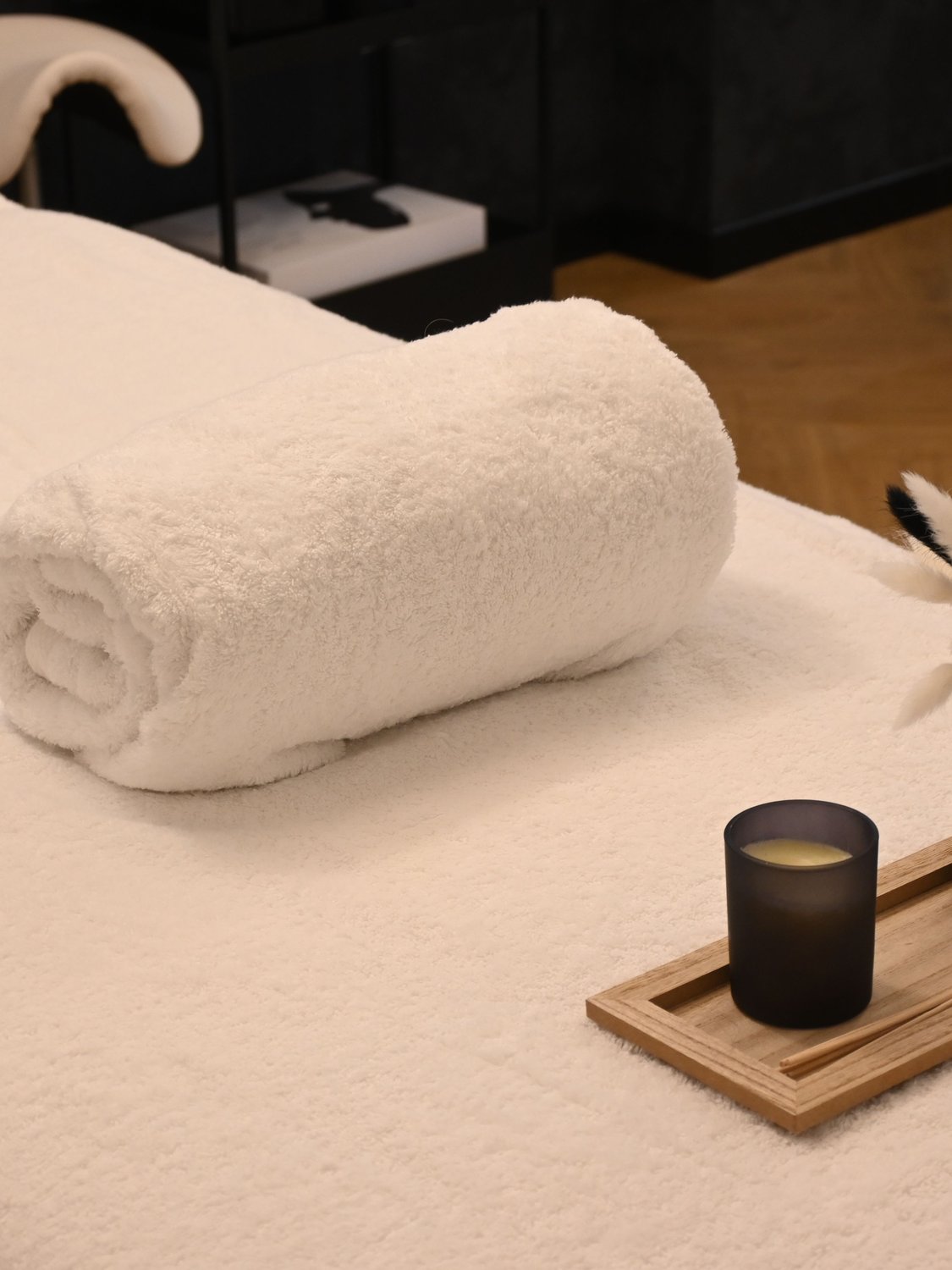 Calm treatment table with a rolled towel and candle, a serene setting for craniosacral therapy