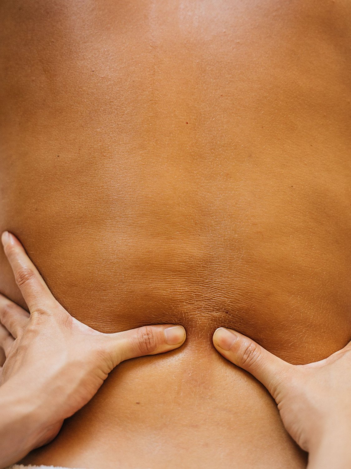 Therapeutic massage, hands easing tension in the back